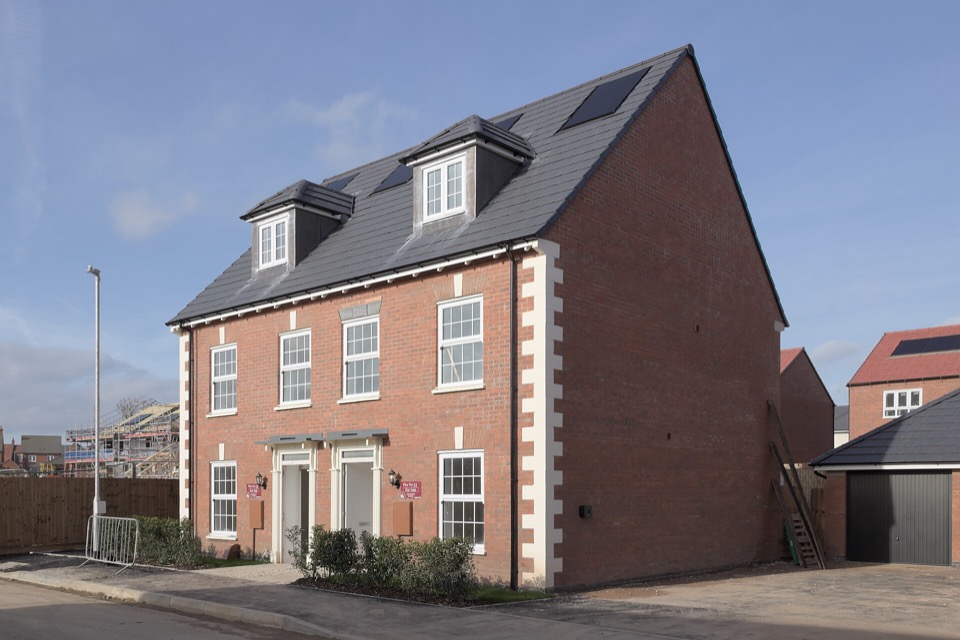 A new-build house with roof panels visible next door, on Inver Road in New Lubbesthorpe, Leicestershire